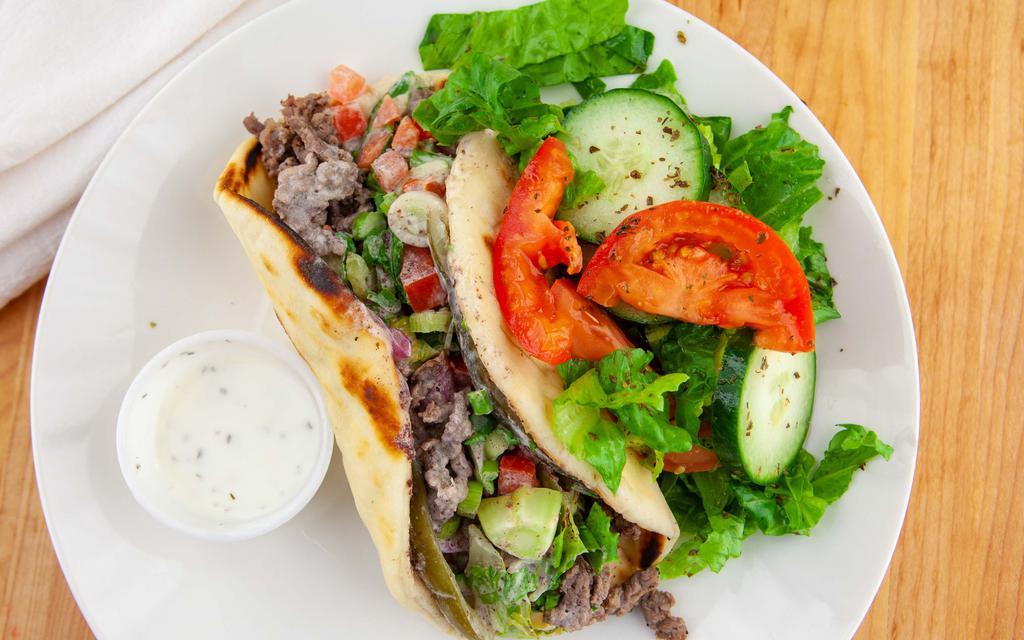 Beef Shawerma Sandwich · Mediterranean version of fajita marinated tenderloin steak with parsley, tomatoes, onions and pickles. Topped with tahini sauce and wrapped in a hot pita bread.