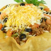 Taco Salad · A homemade taco bowl filled with crisp lettuce, taco meat, a blend of shredded cheeses, dice...