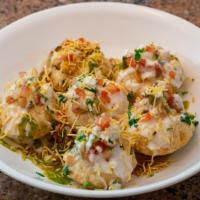 Dahi Puri · Mini puris topped with mashed potatoes, onions, tomatoes, yogurt, chutneys, & garnished with...