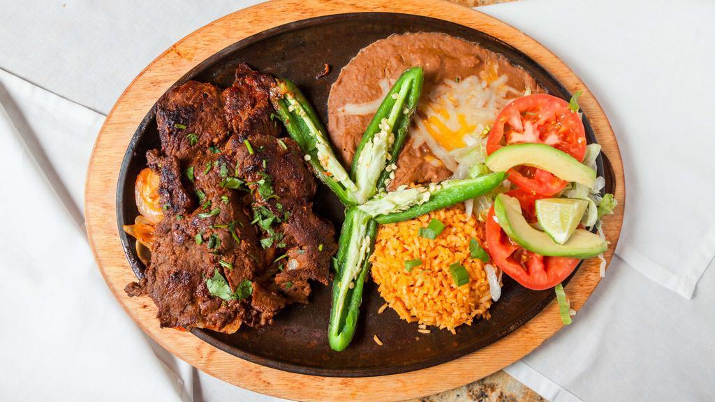 Carne Asada Platillo · 8 oz. Butterfly steak grilled with onions, served with cilantro, sliced tomatoes, avocados, & jalapenos. Served with fresh limes, refried beans, rice, & choice of tortillas.