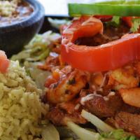 Mi Casa Fajita · Steak, chicken, shrimp, and chorizo sausage all grilled together on top a bed of grilled oni...
