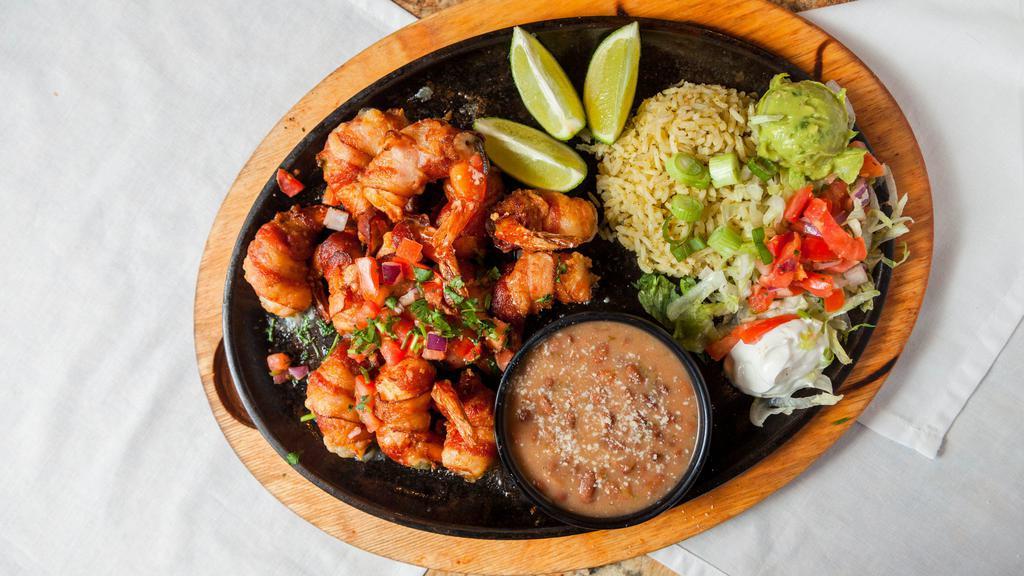 Cancun Shrimp Fajitas · 12 large bacon-wrapped jalapeno and cheese stuffed shrimp, accompanied with lettuce, pico de gallo, guacamole and sour cream. Served with charro beans, rice and flour tortillas.