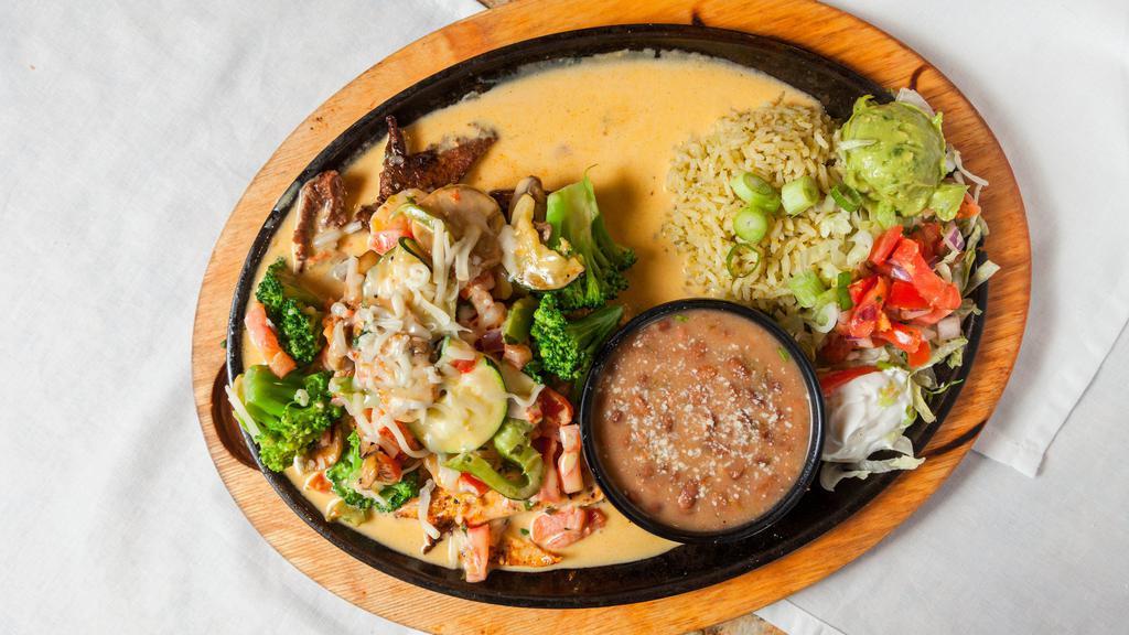 Padre Fajitas · Grilled chicken, shrimp and steak sauteed with broccoli, onions, green peppers and mushrooms, topped with champagne cheese sauce. Served with pico de gallo, guacamole, sour cream, charro beans, rice