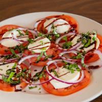 Caprese Salad · A layer of vine ripened fresh tomatoes, topped with fresh mozzarella cheese, red onions, bal...