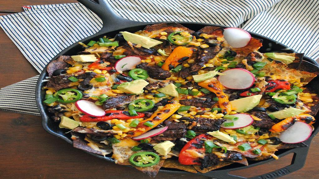 Steak Nachos Supremo · Steak nachos Mexican appetizer the dish has tortillas that are stuffed with tender and juicy meat which has been dressed with a citric marinade. The dish is nothing short of delight.