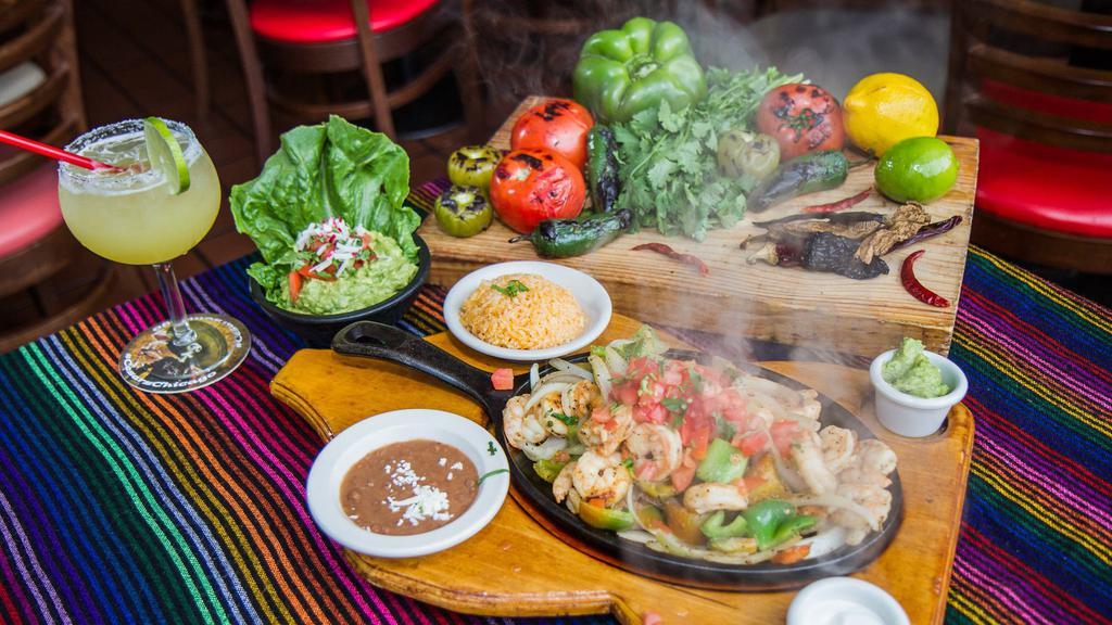 Shrimp Fajitas · Shrimp. Sizzled in a succulent white wine marinade with onions, peppers and tomatoes. Served with tortillas, guacamole and sour cream. Served with rice and beans.