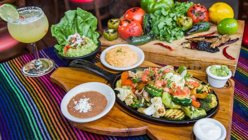 Steak, Shrimp And Chicken Fajitas · Steak, shrimp and chicken. Sizzled in a succulent white wine marinade with onions, peppers and tomatoes. Served with tortillas, guacamole and sour cream. Served with rice and beans.