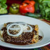 Enchiladas En Mole Poblano · Corn tortillas with your choice of tasty filling. Topped with dark rich mole sauce. Served w...