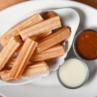 Churros · Homemade bite-sized beignets rolled in cinnamon sugar and served with flavored sauces. Ideal...