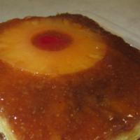 Pineapple Upside Down Cake Slice · Our moist yellow cake baked with Pineapple rings and brown sugar and Maraschino Cherries!