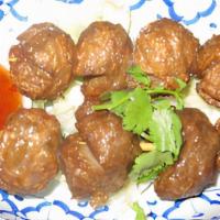 Grilled Meatball · Beef ball on a skewers served on cabbage with homemade sauce on the side.
