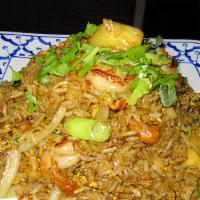 Pineapple Fried Rice · Stir fried rice with pineapple, green onion, onion, curry powder, chicken, and shrimp.