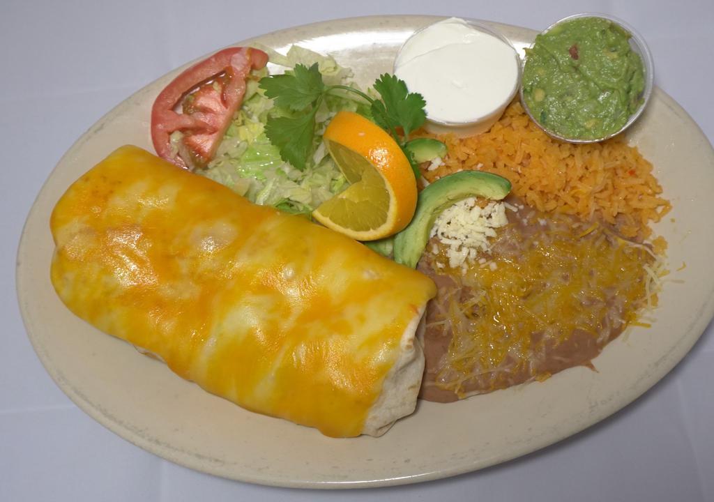 Grande Burrito Dinner · One large burrito with your choice of meat, beans lettuce cheese tomatoes inside, served with rice & beans, side of guacamole and sour cream