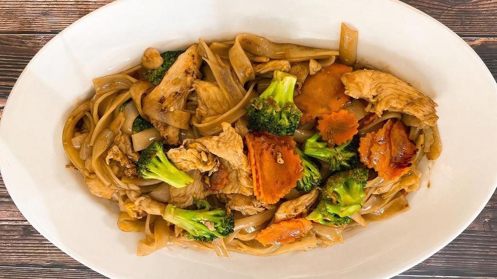 Pad See Ew · The typical Thai street food. Stir-fried large flat rice noodles with egg, broccoli, carrots and your choice of meat in brown soy sauce