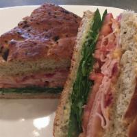 Turkey Focaccia · Smoked turkey breast, bacon with Gouda cheese, forest greens, tomato, and basil aioli.