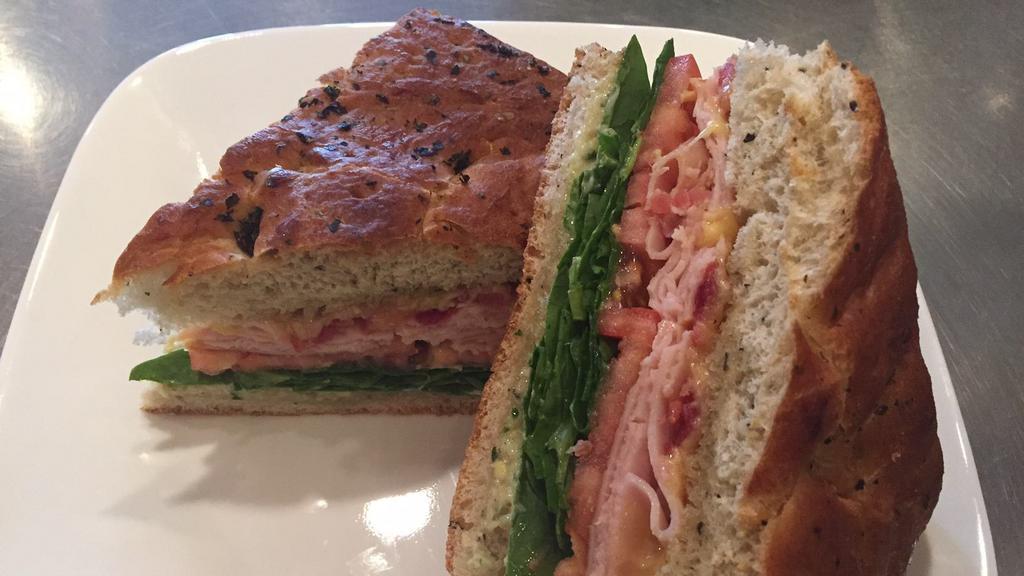 Turkey Focaccia · Smoked turkey breast, bacon with Gouda cheese, forest greens, tomato, and basil aioli.