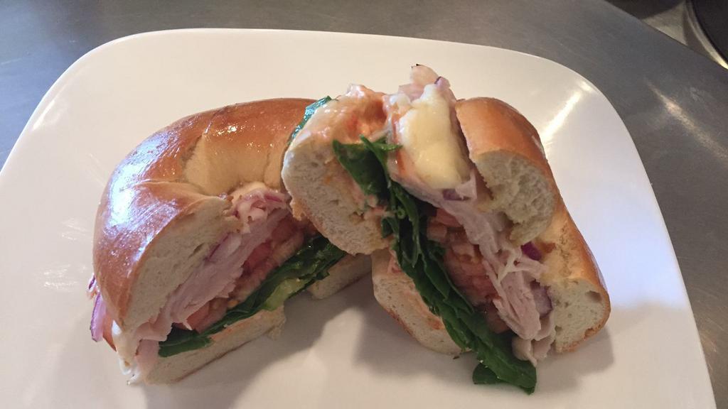 Turkey Bagel · Smoked turkey with provolone cheese, tomato, red onion, forest greens, and sundried tomato cream cheese.