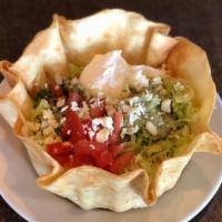 Taco Salad · Crispy flour tortilla shell with beef or chicken, beans, lettuce, tomatoes, and guacamole.