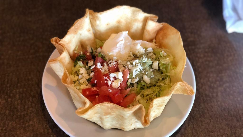 Taco Salad · Crispy flour tortilla shell with beef or chicken, beans, lettuce, tomatoes, and guacamole.