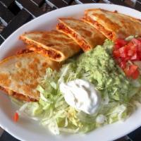 Quesadillas Rellenas · Two flour grilled flour tortillas stuffed with cheese and chopped beef or chicken. Served wi...