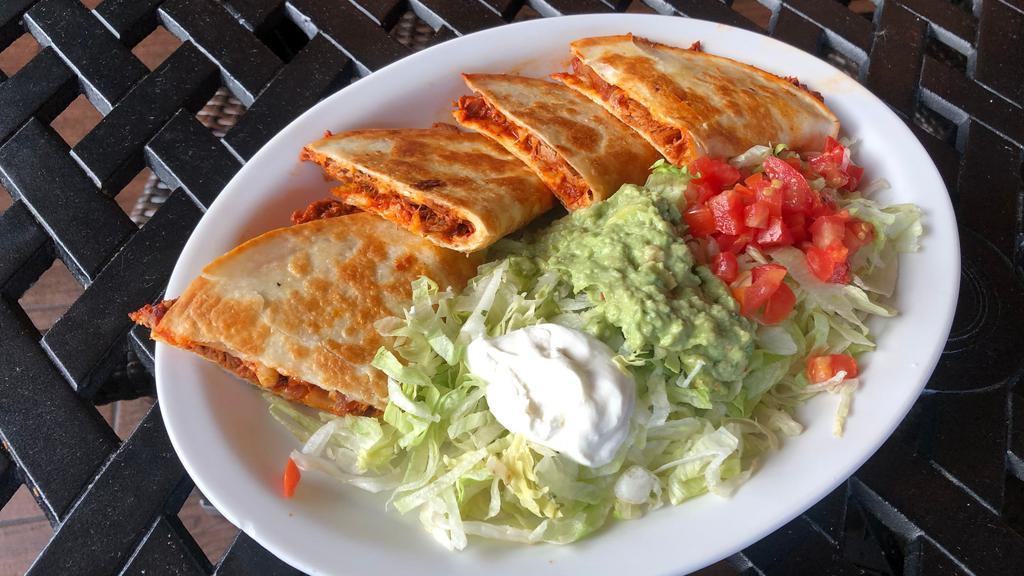 Quesadillas Rellenas · Two flour grilled flour tortillas stuffed with cheese and chopped beef or chicken. Served with guacamole salad and sour cream.