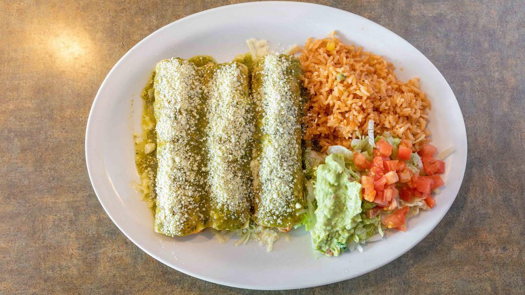 Enchiladas Verdes · Three rolled corn tortillas filled with shredded chicken. Topped with tomatillo sauce and Cotija cheese. Served with guacamole salad and rice.