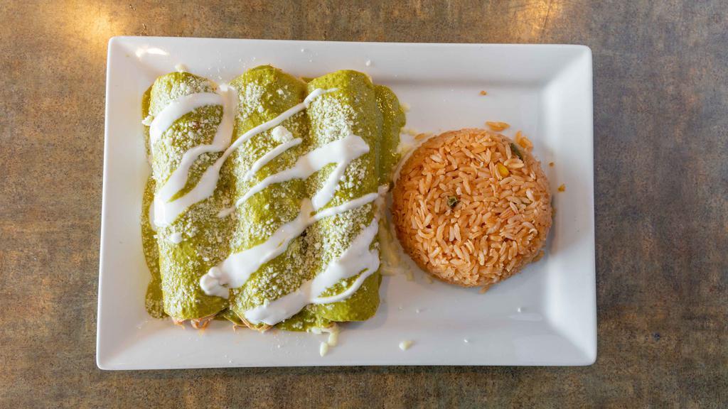 Enchiladas Suizas · three chicken enchiladas coverd in a special creamy poblano sauce topped with cotija cheese and sour cream served with rice