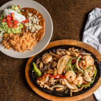 Texas Fajitas · Tender sliced chicken, beef and shrimp sautéed with bell peppers, tomatoes, and onions. mush...