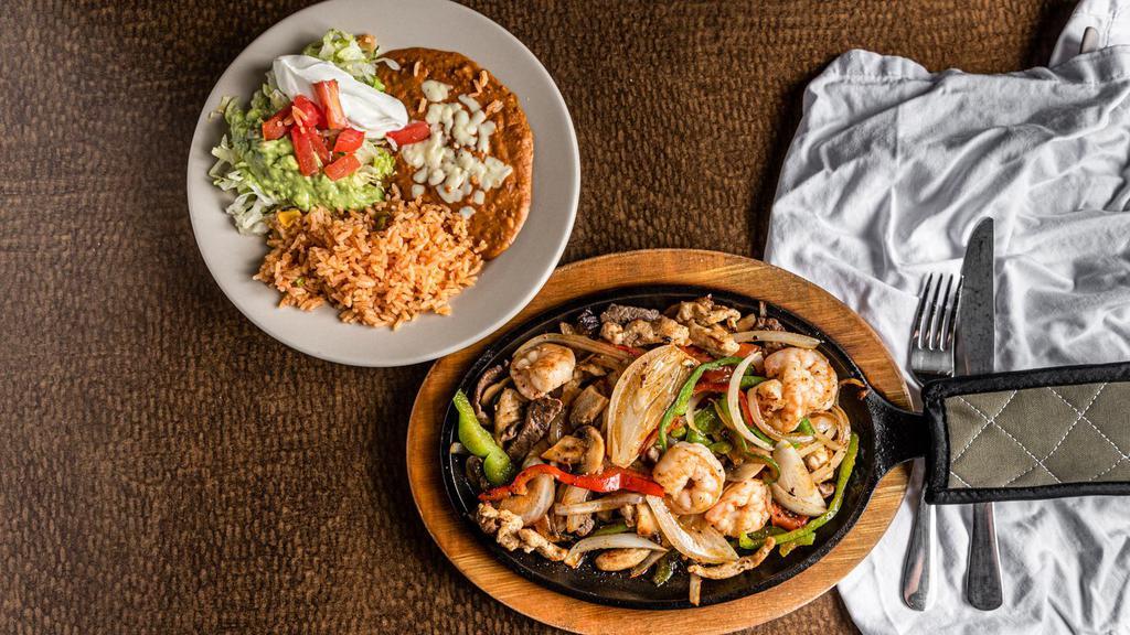 Texas Fajitas · Tender sliced chicken, beef and shrimp sautéed with bell peppers, tomatoes, and onions. mushrooms and tomatoes. Served with guacamole salad and beans.