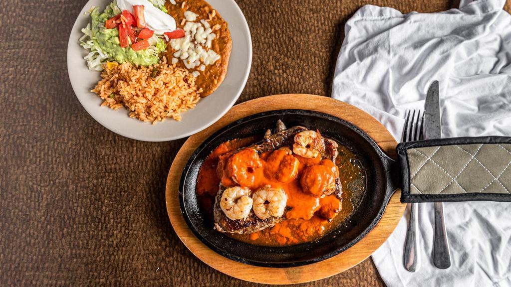 Steak & Camarones · Rib-eye steak and shrimp with ranchero sauce. Served with rice, beans, and guacamole.