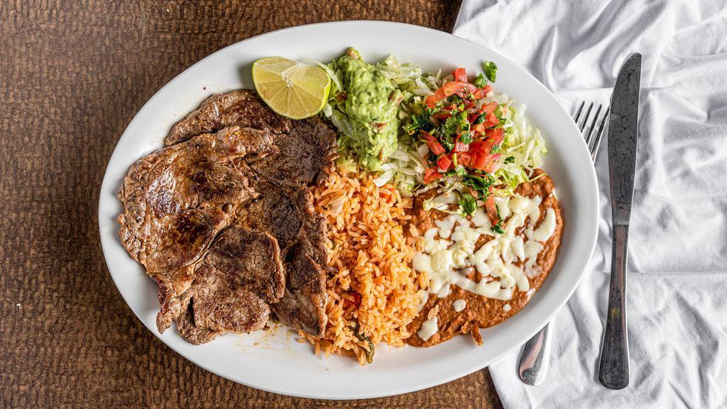 Carne Asada · Tender grilled beef with beans, rice, and guacamole salad. Served with tortillas.