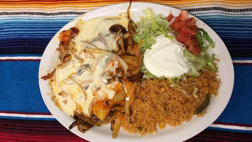Pollo Marina · Marinated, grilled chicken breast with grilled onions, mushrooms, and melted cheese. Served with rice, lettuce and sour cream.