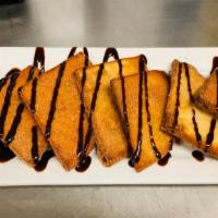 Sopapillas · Six flat and puffy pieces of pastry covered with honey, cinnamon and chocolate syrup.