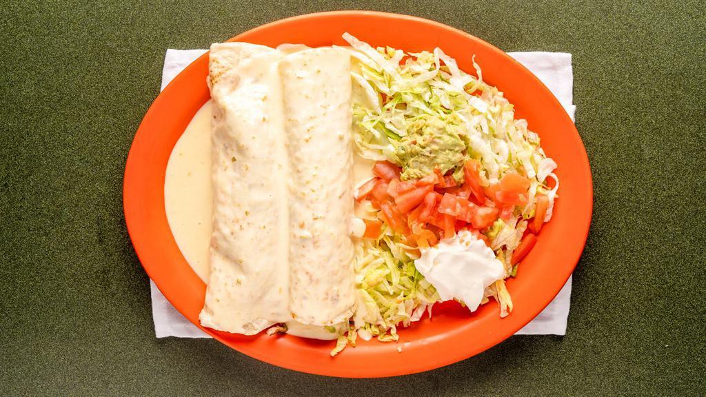 Burritos Parian · Two burritos filled with grilled beef or chicken, served with lettuce, tomatoes, onions and sour cream. Topped with nacho cheese sauce.