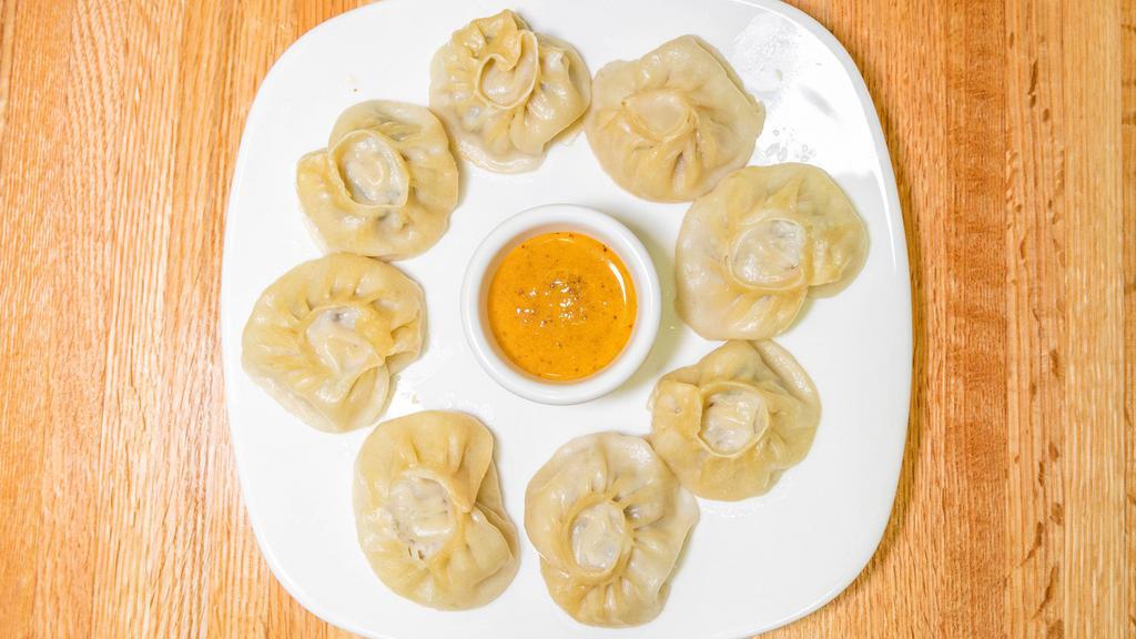 Pork Momo · pork marinated in traditional Bhutanese or Nepali herbs, spices wrapped in multipurpose flour thin bread and steamed to cook. Served with traditional homemade hot sauce.