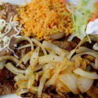 Milanesa · 2 breaded ribeye steaks - Served with rice and beans. Add grilled onions for an additional c...