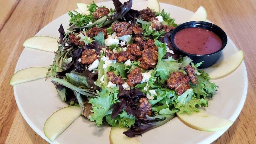 Apple And Candied Walnut Salad · Organic leaf lettuce with candied walnut halves, apples, and feta cheese with a side of raspberry walnut dressing.