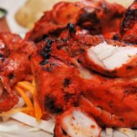 Tandoori Chicken · Roasted chicken marinated overnight with yogurt, ginger, garlic, and organic herbs barbequed...