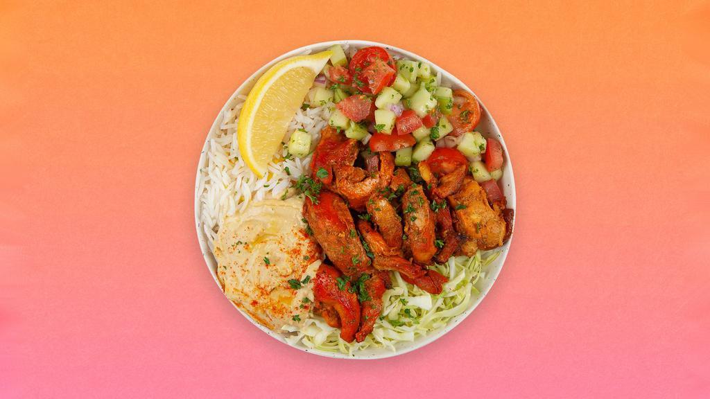 Chicken Kebab Rice Bowl · Grilled chicken over basmati rice with hummus, diced cucumber and tomato salad, shredded green cabbage and a drizzle of tahini sauce.