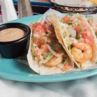 Baja Shrimp Tacos · Three flour tortillas filled with seasoned, grilled shrimp, lettuce, pico de gallo and our c...