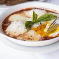 Eggs Parmigiano · spicy marinara, fresh mozzarella and the three eggs baked and topped with basil and Parmigia...