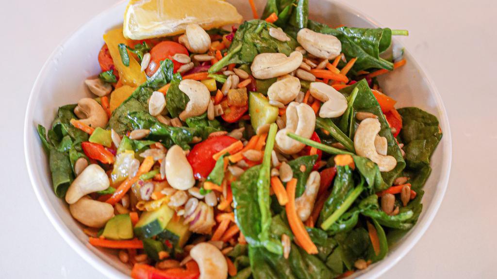 Veggie Tales · raw cucumber, tomato, red onion, pepper, carrots, cabbage, spinach tossed in house ginger turmeric dressing topped with cashews, sunflower seeds 
& a wedge of lemon