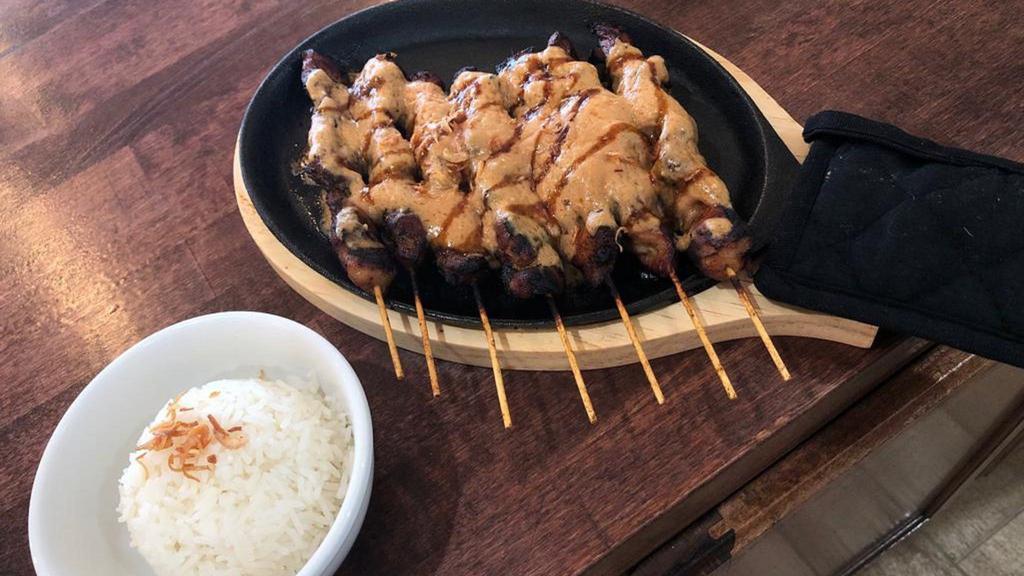 Sate Ayam · Grilled chicken-on-skewer. Served with rice and peanut sauce.