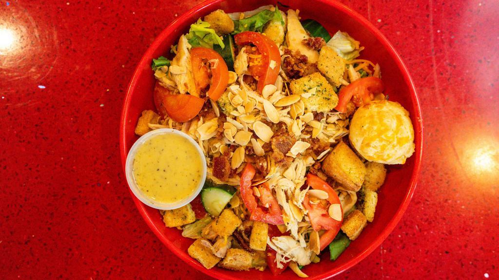 Chicken Scratch Salad · Fresh garden greens, choice of fried or rotisserie chicken, tomatoes, cucumbers, chopped bacon, toasted almonds, cheddar and housemade croutons with choice of dressing.