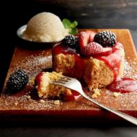 Berry Butter Cake · Warmed cream cheese butter cake, vanilla ice cream, strawberry sauce, and fresh berries.