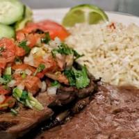 Carne Asada · Served with rice beans salad and freshly made tortillas.