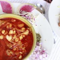 Pozole · Red pork broth with tender pork meat and white hominy served with a bean tostada or corn tor...