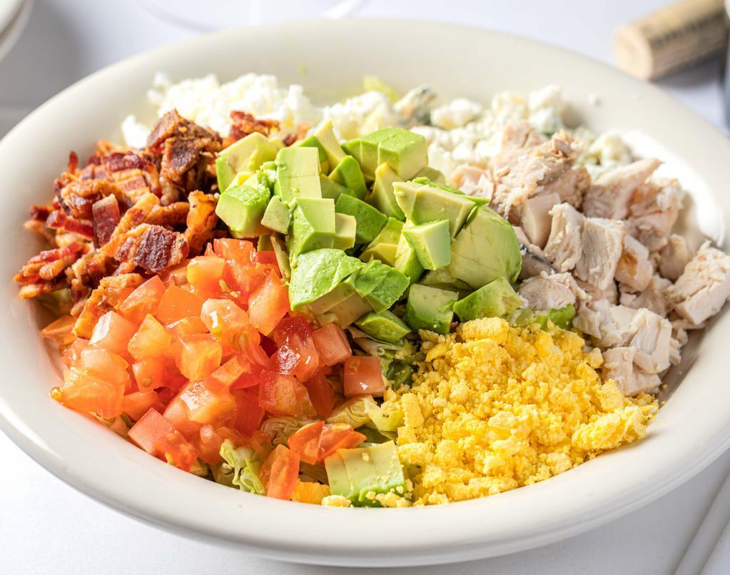 Cobb Salad · ICEBERG AND ROMAINE LETTUCE TOSSED IN HOUSE VINAIGRETTE. TOPPED WITH CRUMBLED BLUE CHEESE, TOMATO, BACON, AVOCADO, HARD BOILED EGG WHITES AND YOLKS, ROASTED CHICKEN