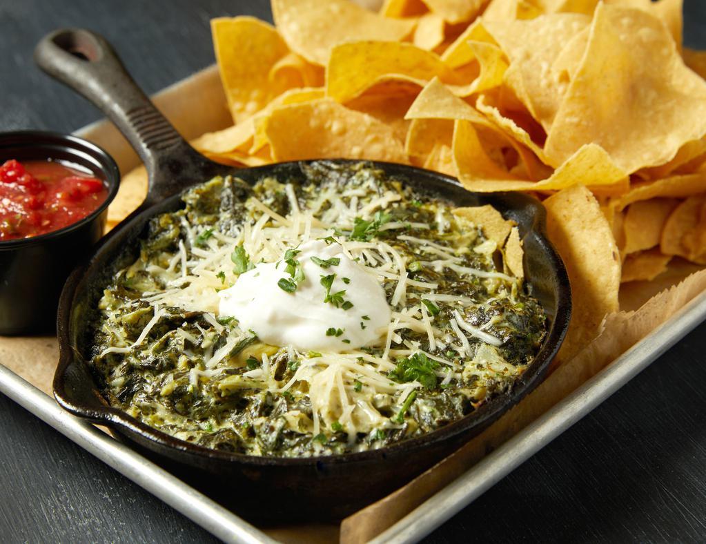 Spinach & Artichoke Dip · A delicious blend of spinach, artichokes, garlic, Monterey Jack, Romano and Parmesan cheeses simmered together and served with house made salsa and chips.