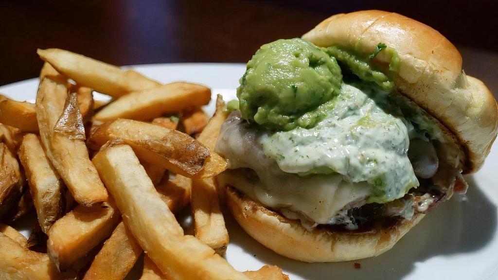The Chimi Burger · Two smashed-cooked patties topped with Monterey Jack cheese, avocado mousse, caramelized onions, smoked bacon and house made chimichurri sauce on a butter-toasted bun.
